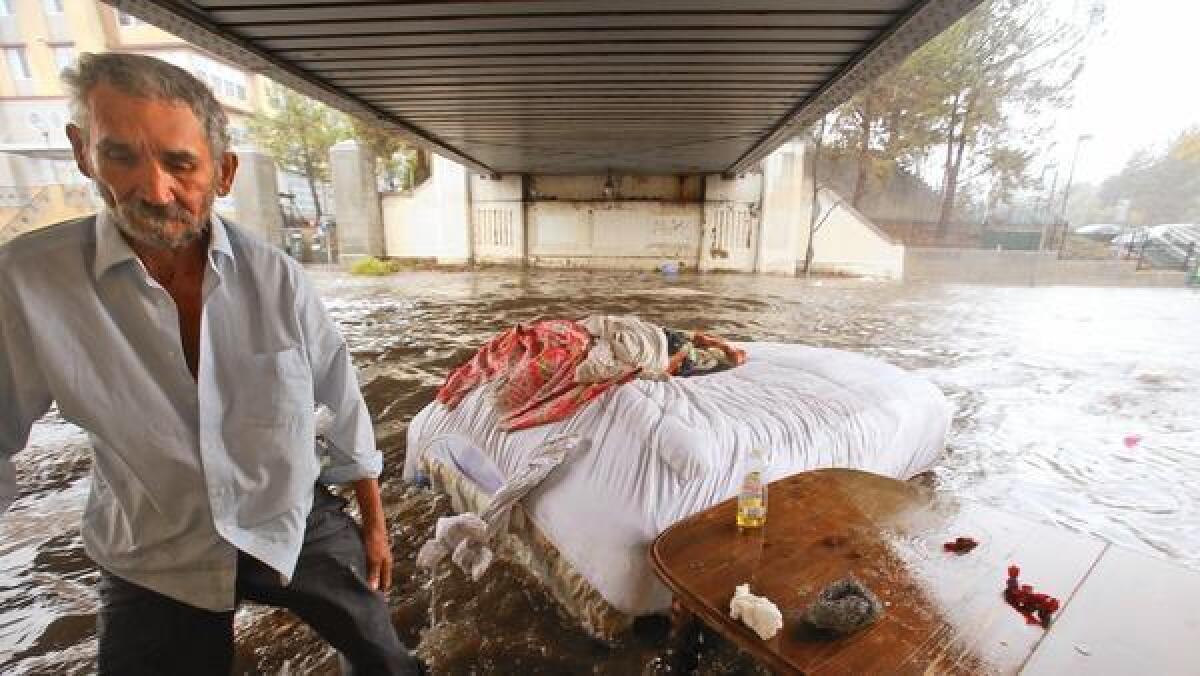 La cama de Felipe Flores López, de 59 años de edad, se va flotando mientras el agua de la lluvia inunda una sección de la Avenida 26 por debajo la Estación de la Línea Dorada de Cypress Park/ Lincoln Heights en Lincoln Heights.