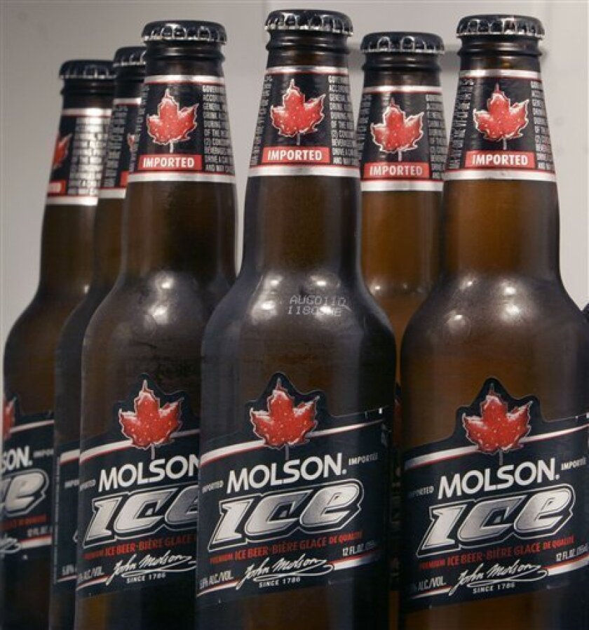 FILE - In this file photo taken May 3, 2010, a display of Molson Ice beer sits arranged in a refrigerator in Marborough, Mass. Molson Coors Brewing Co.'s net income fell 21 percent in the first quarter on rising costs for ingredients and fuel Tuesday, May 3, 2011. (AP Photo/Bill Sikes, file)