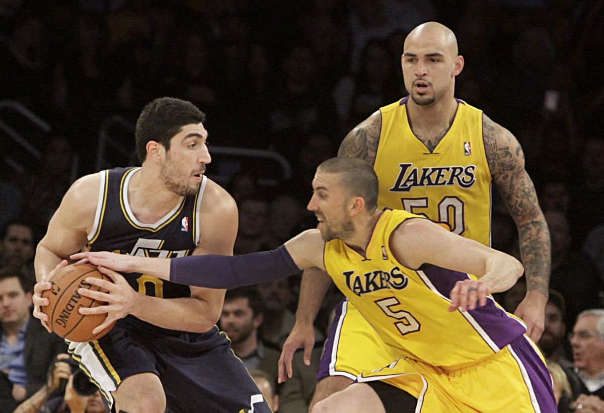 Utah's Enes Kanter holds the ball as Steve Blake reaches in during the second half of the Lakers' loss Tuesday to the Jazz, 96-79, at Staples Center.