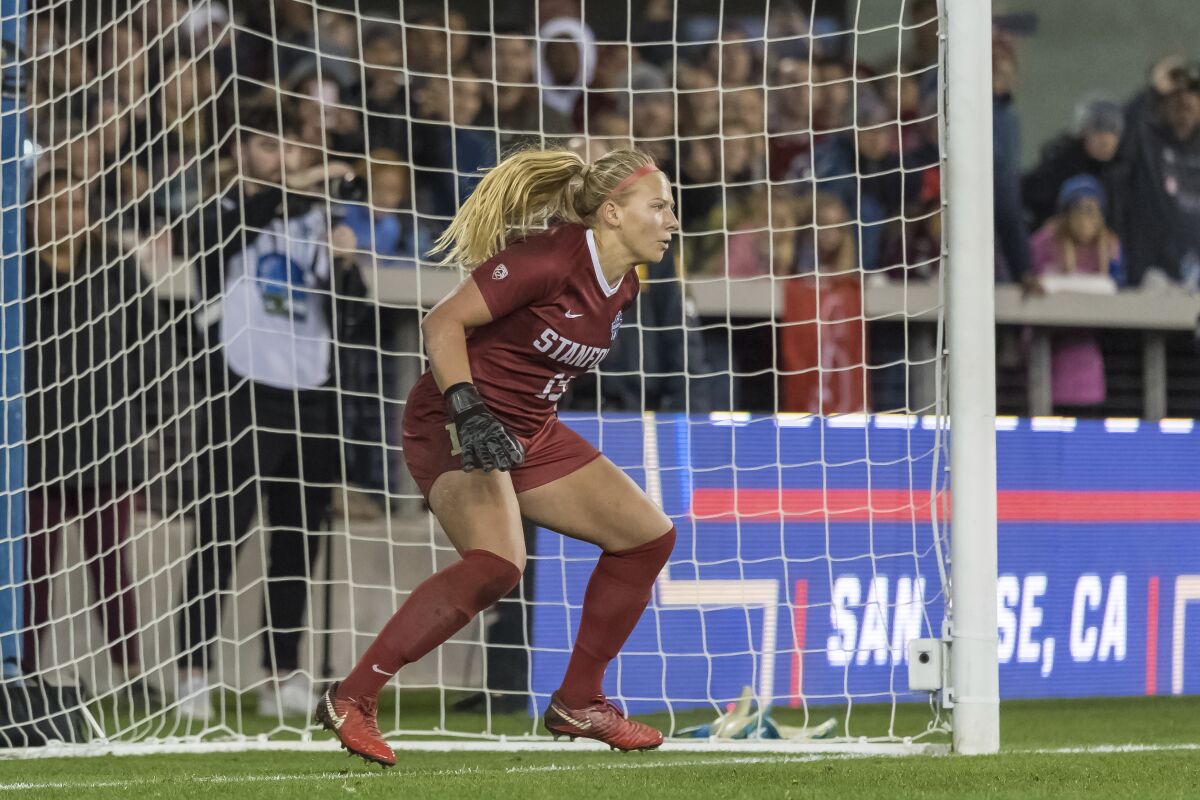 A soccer goaltender stands ready to defend a shot in front of the goal.