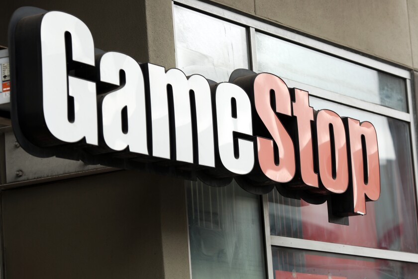 A white and red GameStop sign on outside of a store