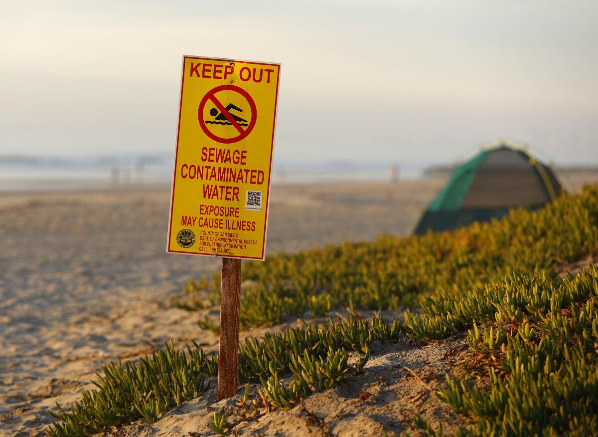 A water contamination sign warns beach goers about high bacteria