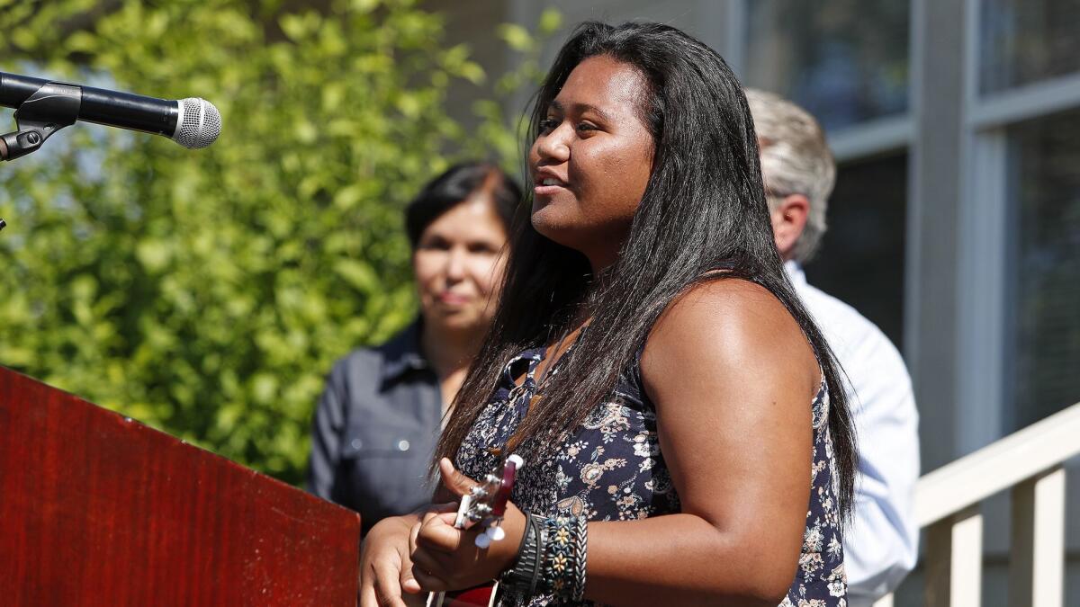 Martha Misikei, 18, of Anaheim, a former resident of the Huntington Beach Youth Shelter, strums her ukulele as she sings a song she wrote, “Ain’t Going Down,” during a shelter anniversary reception Thursday.