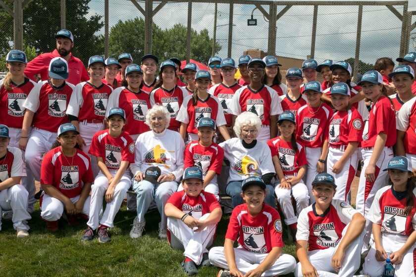 Maybelle Blair and Shirley Burkovich pose for photos with the Boston Slammers during a Baseball For All event.