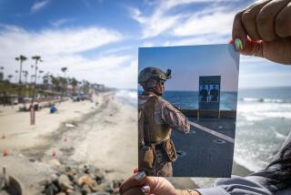 Oceanside, CA - March 06: Shalena Critchlow, former military spouse and military parent, who's son served in Marines when Israel and Gaza conflict broke out, regional organizer with Secure Families Initiative, holds a photo of her son, Cpl. Saiveon Critchlow, shown in 2004, aboard the USS Carter when he was serving in the First Battalion, Six Marine Regiment at the Oceanside Pier Friday, March 6, 2026. Critchlow says she supports military and families and transparency. Critchlow's family are descendants of the Luiseno Rincon Band of Indians and Mesa Grande. (Allen J. Schaben / Los Angeles Times)