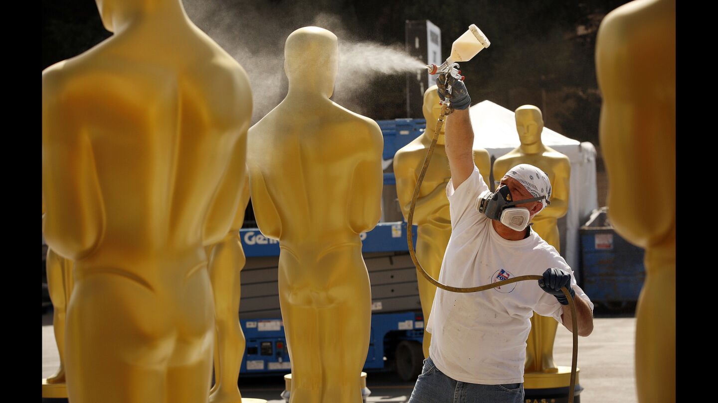 Scenic artist Rick Roberts touches up the Oscar statue props that are slated for placement on the red carpet and at the Dolby Theatre amid preparations for Sunday's Academy Awards in Hollywood.