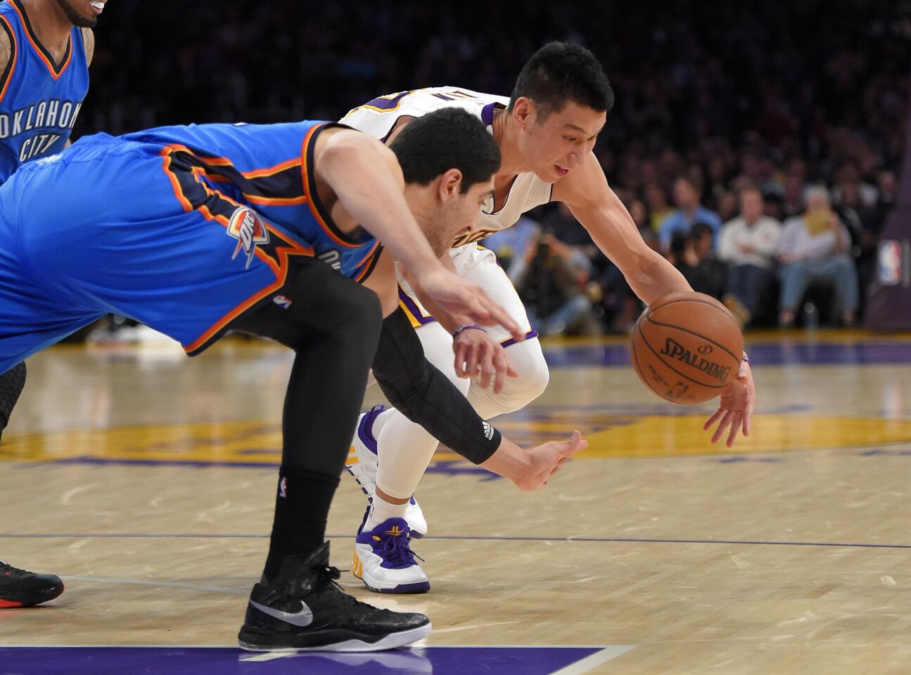 Lakers point guard Jeremy Lin and Thunder center Enes Kanter both go after a loose ball during the first half.