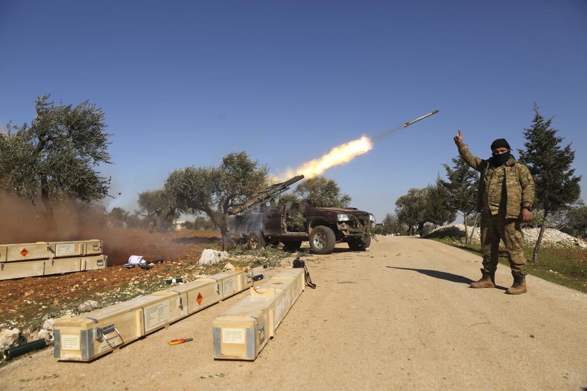 Rebel fighters fire a missile toward Syrian government positions in the province of Idlib on Sunday. Syria's military vowed to keep up its campaign to regain control of the whole country, days after capturing large chunks of territory from the last rebel holdout in northwestern Syria.