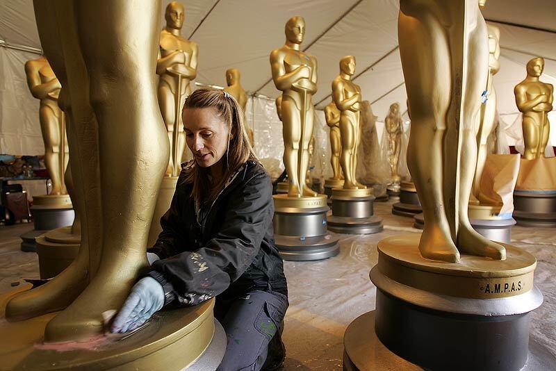 Scenic artist Gayle Etcheverry sands the base of a fiberglass Oscar statue that will adorn the red carpet at the Kodak Theatre in Hollywood for the 81st Academy Awards on Sunday.