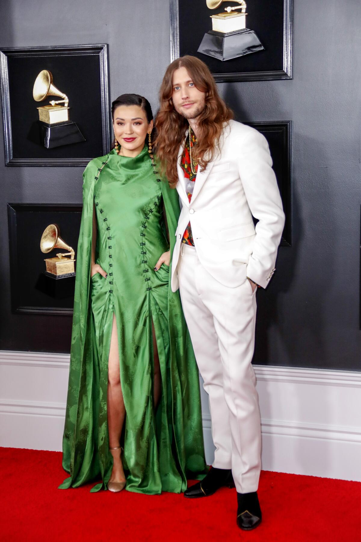 Serena McKinney, in a green dress, and Ludwig Göransson, in a white suit, on the red carpet at the 61st Grammy Awards.
