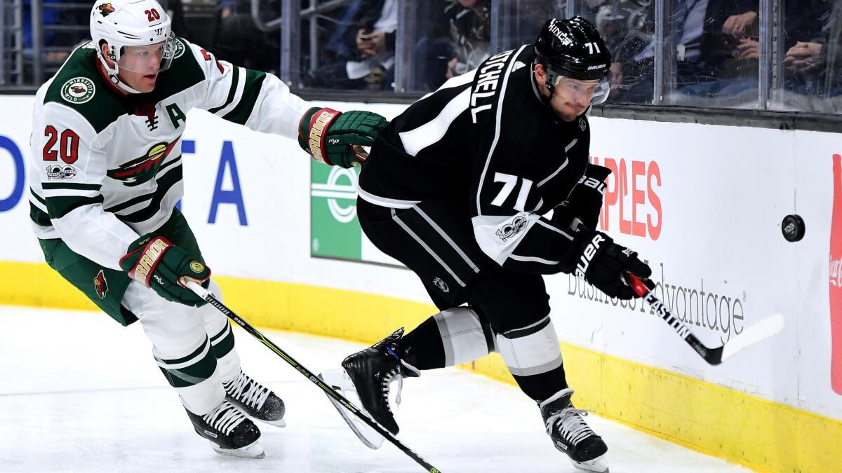 Kings center Torrey Mitchell keeps the puck away from Wild defenseman Ryan Suter during a game earlier this month.