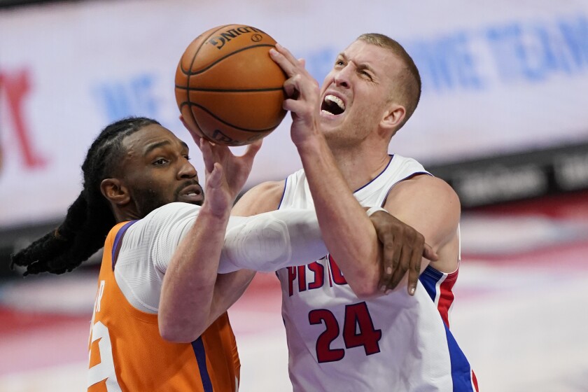 Detroit Pistons center Mason Plumlee (24) is fouled by Phoenix Suns forward Jae Crowder during the second half of an NBA basketball game, Friday, Jan. 8, 2021, in Detroit. (AP Photo/Carlos Osorio)