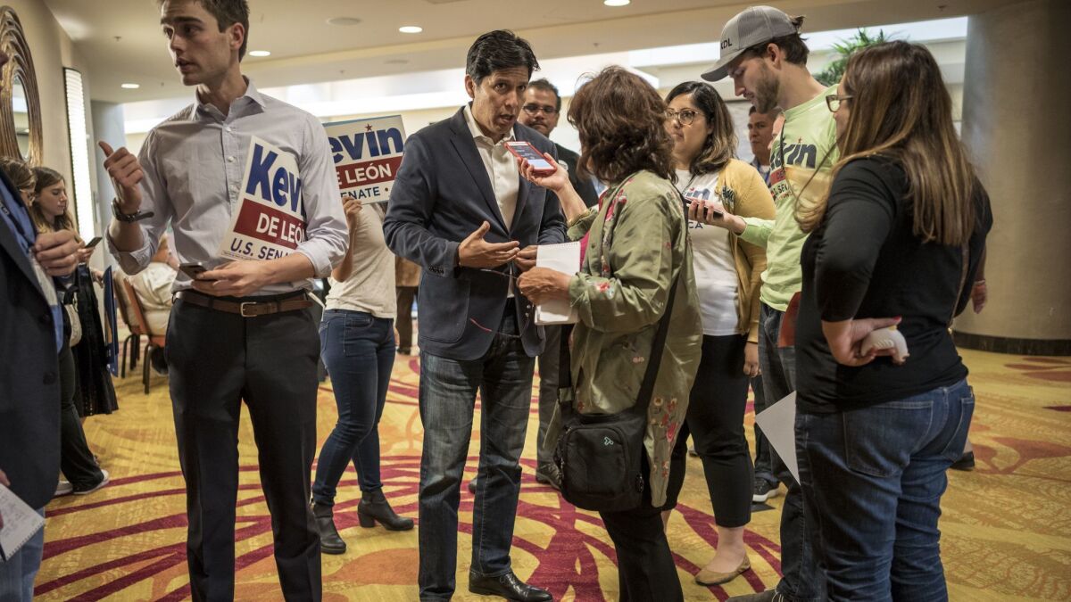 Kevin de Leon, center, speaks to reporters during Democratic state caucus meetings at the Marriot Hotel in downtown Oakland. Kevin de Leon and Diane Feinstein are competing for the endorsement of the California Executive Committee.