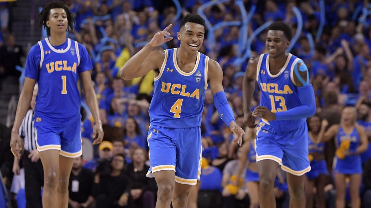 UCLA's Jaylen Hands, center, celebrates after hitting a three-point shot as Moses Brown, left, and Kris Wilkes follow during the Bruins' win over USC on Feb. 28.