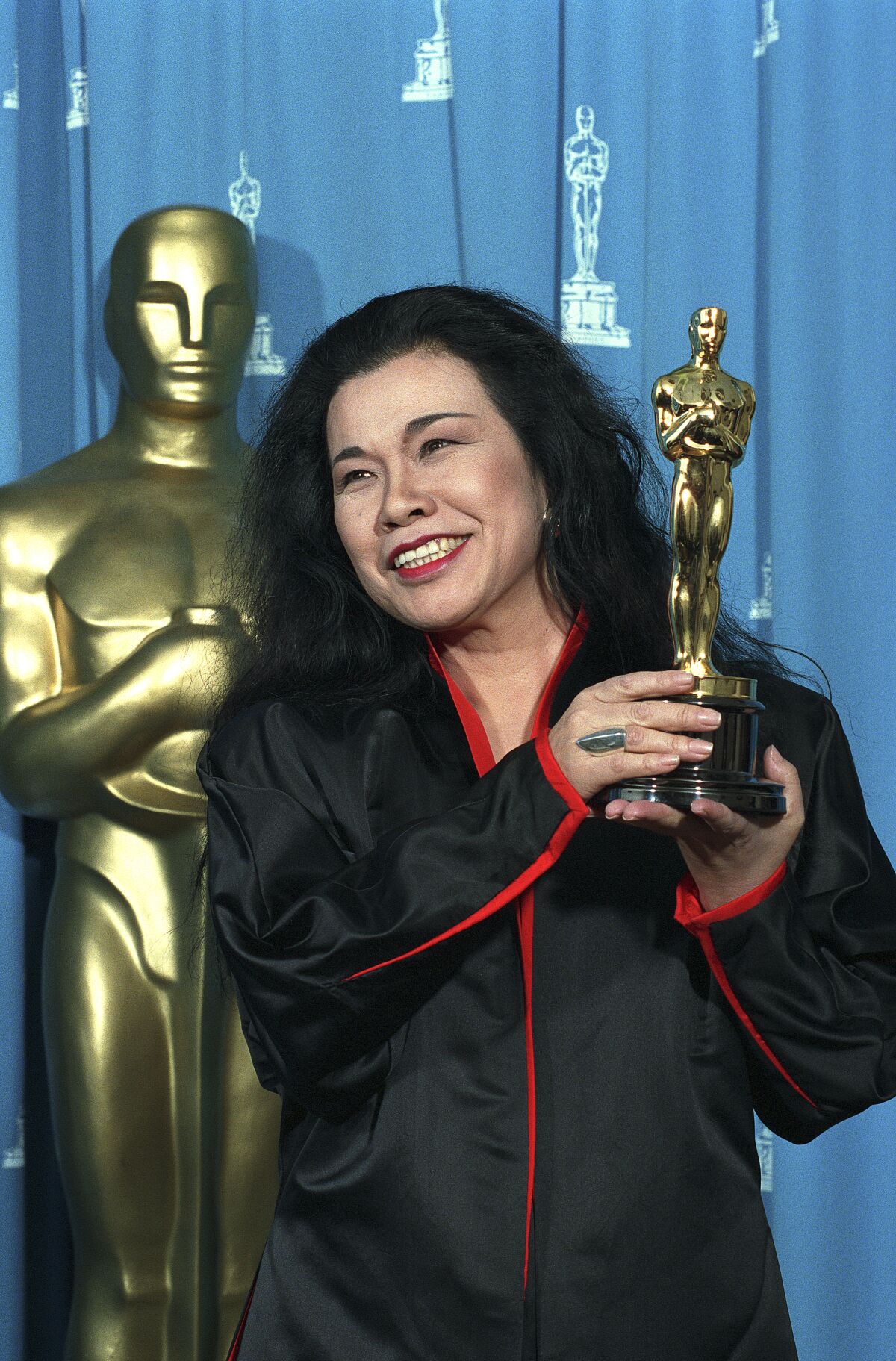 Eiko Ishioka holds her Oscar backstage at the 65th Academy Awards ceremony in 1992.