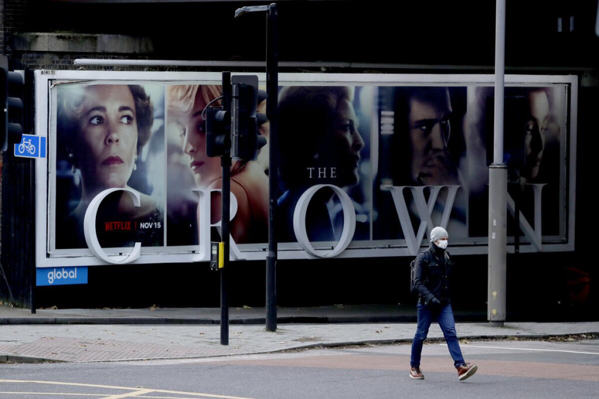 ARCHIVO - un hombre pasa frente a un anuncio de la serie de Netflix "The Crown" en Londres.