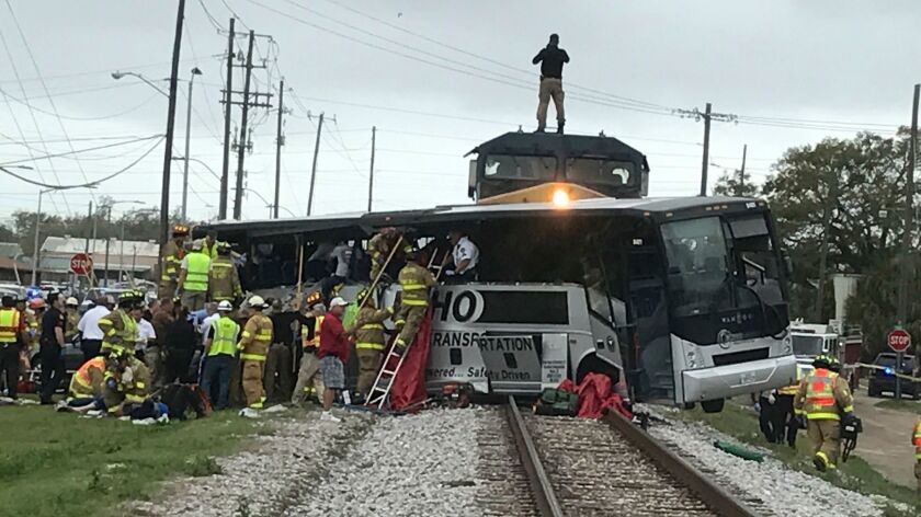 Firefighters assist injured passengers after a charter bus was hit by a freight train in Biloxi, Miss.