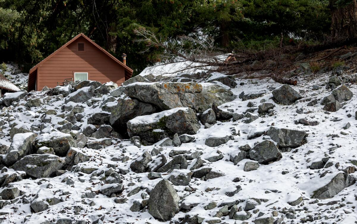 Snow covers a rocky hillside near a small cabin along Mt. Baldy Road 