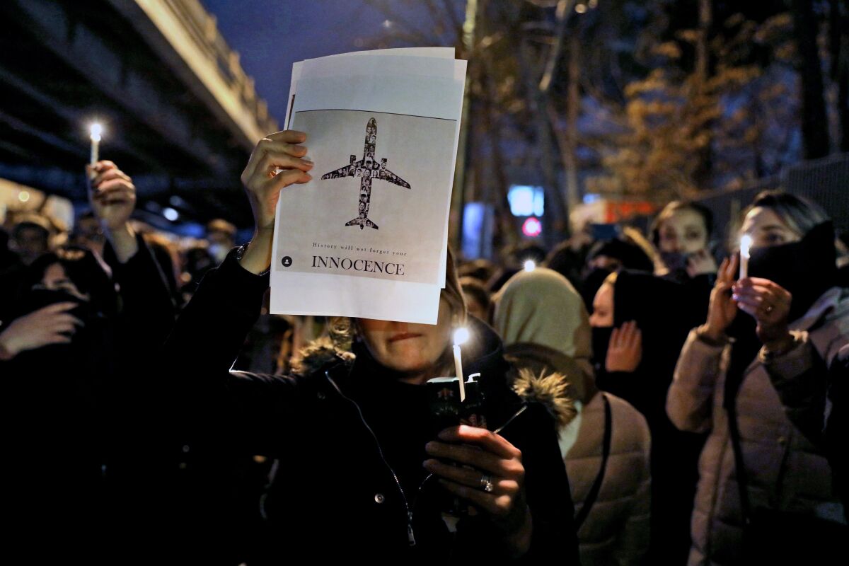 People gather for a candlelight vigil to remember the victims of a Ukraine plane crash