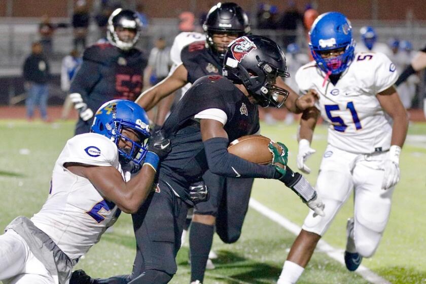 Dymally runner Bryant Collins gains a first down before being dragged down by Crenshaw’s Jeremiah Blackmon.