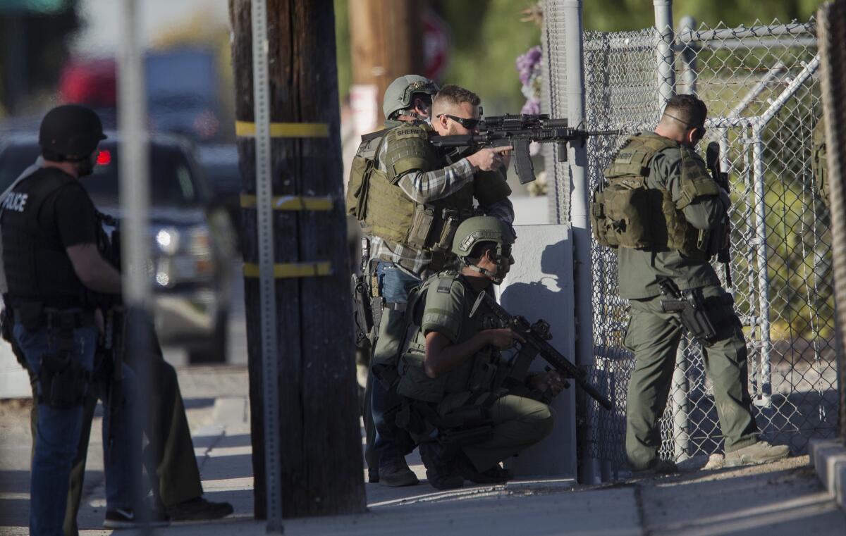 SWAT officers search Wednesday near Victoria Elementary School in San Bernardino for the suspects involved in the mass shooting that killed 14 people at the Inland Regional Center.
