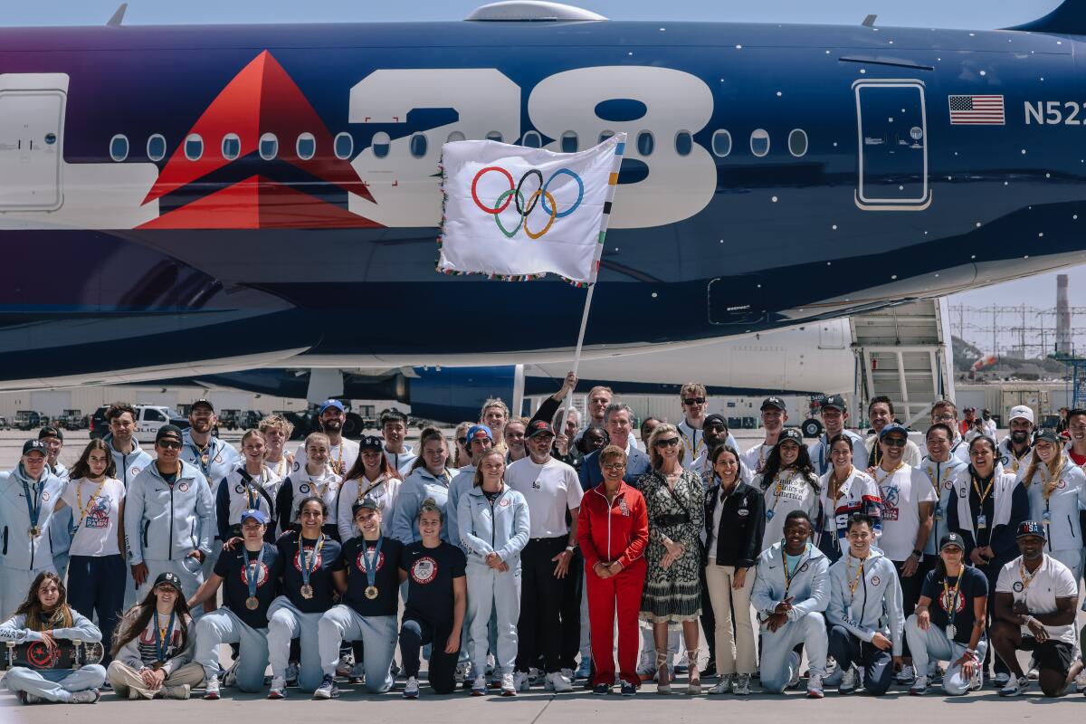 L.A. mayor Karen Bass and Gov. Gavin Newsom with the official Olympic flag as it returns to LA