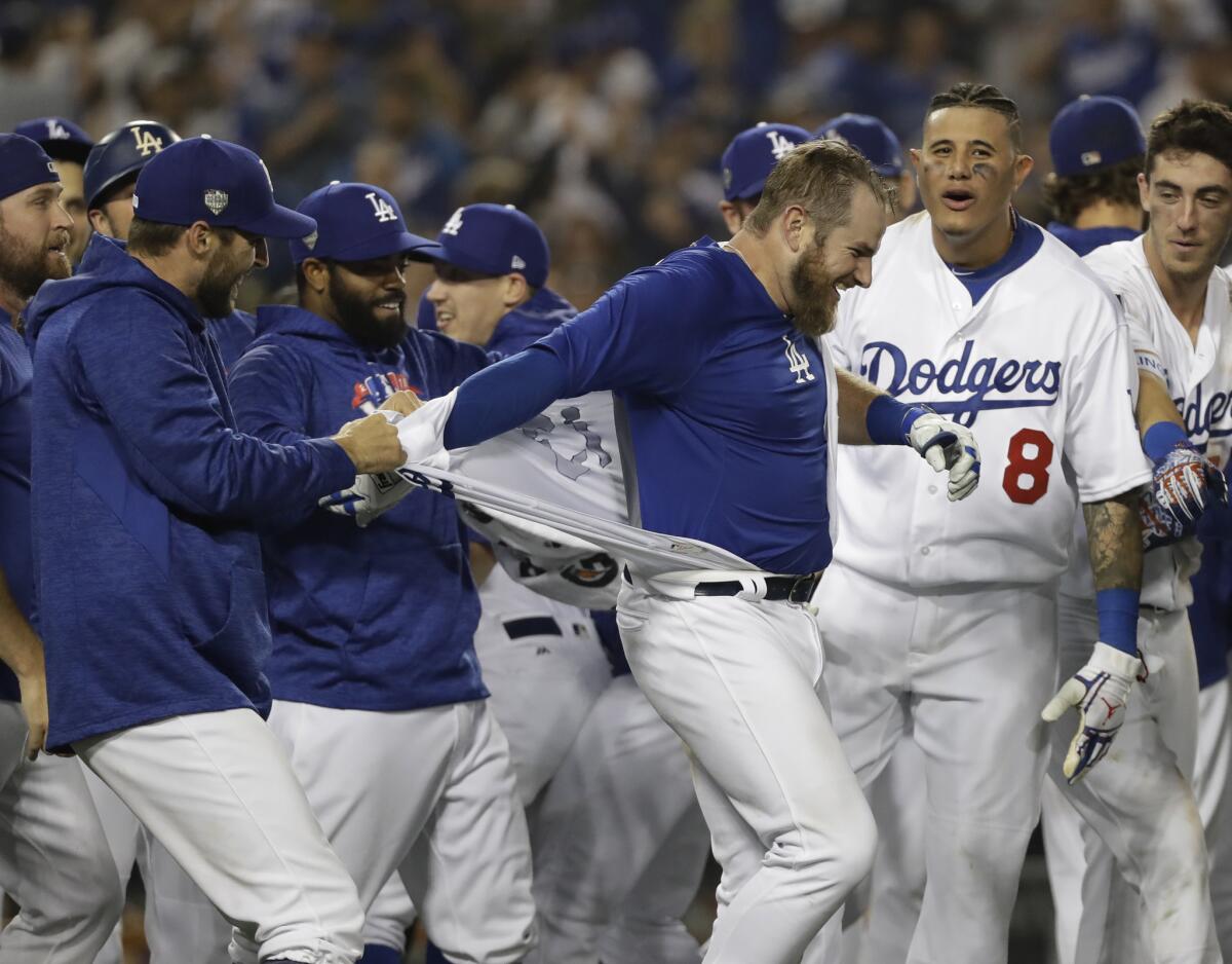 Los Angeles Dodgers tear off Max Muncy's jersey after his walk off home run during the 18th inning in Game 3 of the World Series baseball game to defeat the Boston Red Sox 3-2 on Saturday, Oct. 27, 2018, in Los Angeles.
