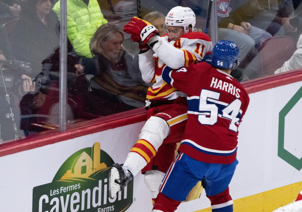 Calgary Flames' Mikael Backlund is checked by Montreal Canadiens' Jordan Harris during the second period of an NHL hockey game in Montreal, Monday, Dec. 12, 2022. (Paul Chiasson/The Canadian Press via AP)