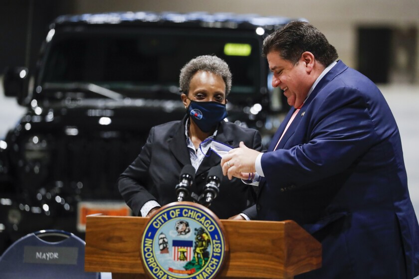 Governor J.B. Pritzker and Mayor Lori Lightfoot talk following a news conference regarding updates on Chicago's reopening efforts at McCormick Place in Chicago on Tuesday, May 4, 2021. (Jose M. Osorio /Chicago Tribune via AP)