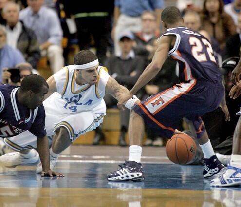 UCLA's Lorenzo Mata dives for a loose ball against Cal State Fullerton Titans Justin Burns, left and Ray Reed, right.