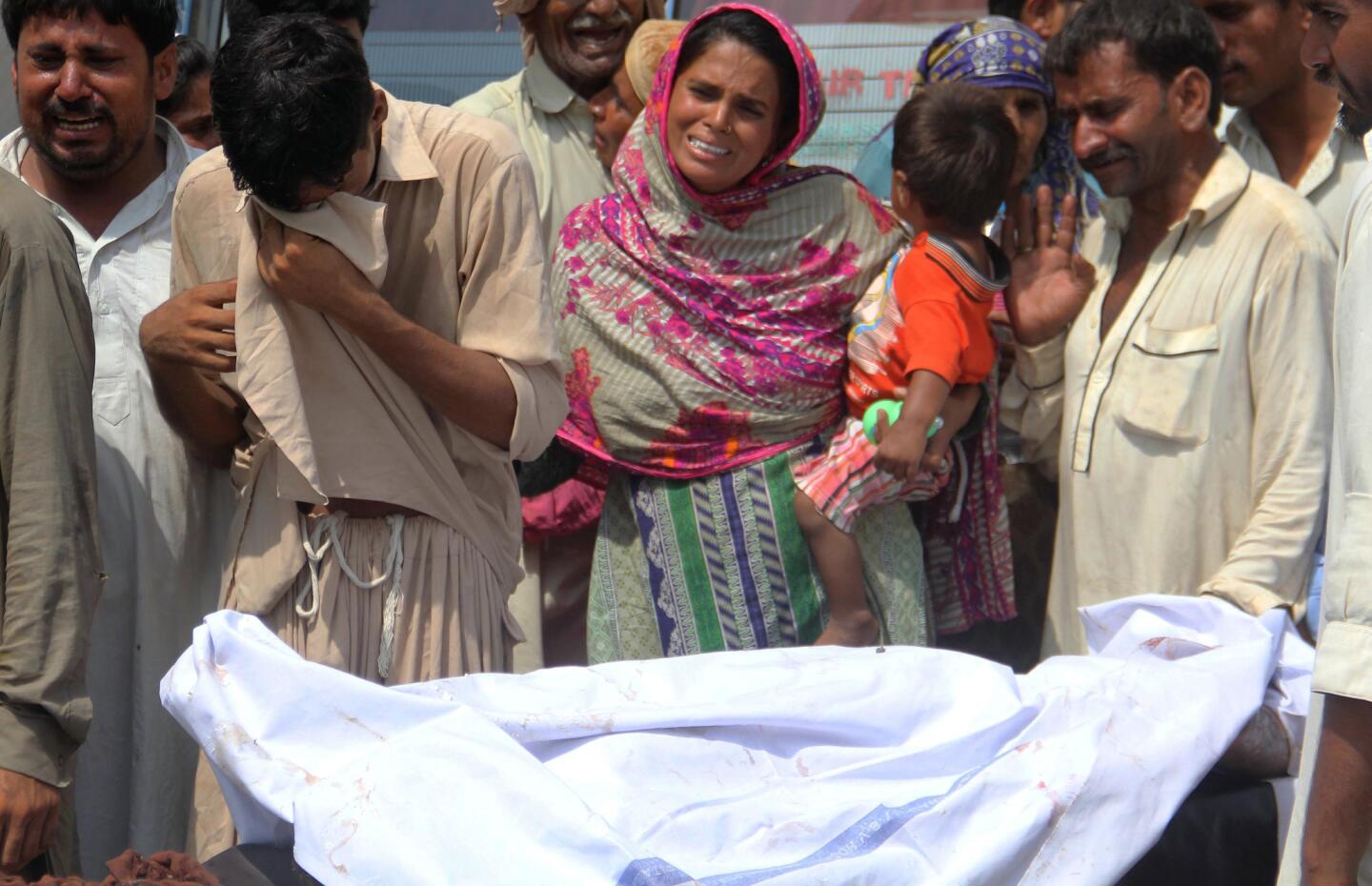 Relatives weep over a body at a hospital in Bahawalpur, Pakistan, after the oil truck fire.