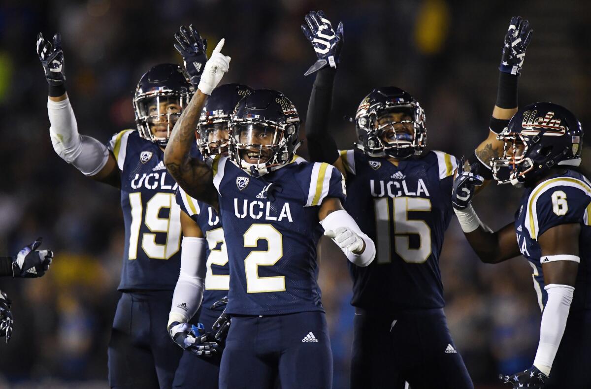 UCLA players gesture to the crowd during the first half of a game against Oregon State at the Rose Bowl on Nov. 12.