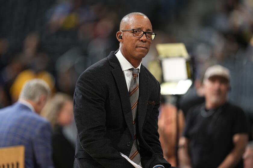 San Antonio Spurs lead television analyst Sean Elliott in the first half of an NBA basketball game Tuesday, April 2, 2024, in Denver. (AP Photo/David Zalubowski)