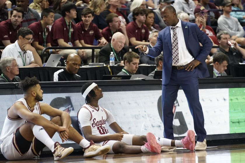 Boston College head coach Earl Grant, right, talks with guard Chas Kelley, center, and forward CJ Penha Jr., left, during the first half of an NCAA college basketball game against Louisville at the Atlantic Coast Conference Tournament in Greensboro, N.C., Tuesday, March 7, 2023. (AP Photo/Chuck Burton)