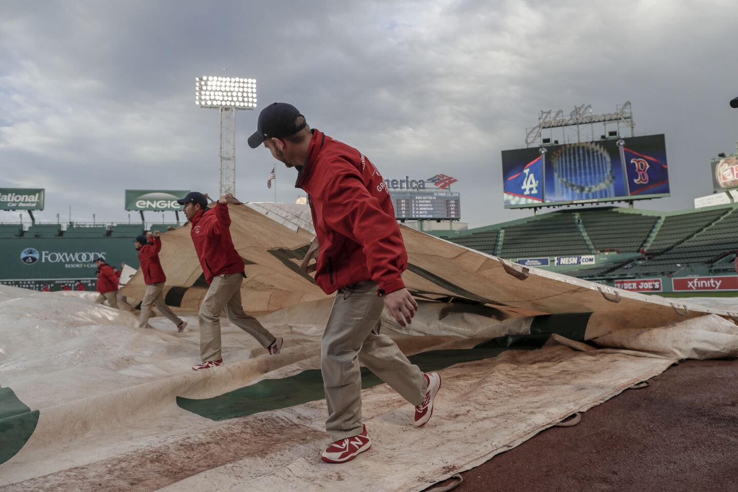 Fenway Park grounds crew members pull a tarp off the field soon after a heavy rainstorm passed by hours before the LA Dodgers and the Boston Red Sox play game one of the 2018 Word Series at Fenway Park.