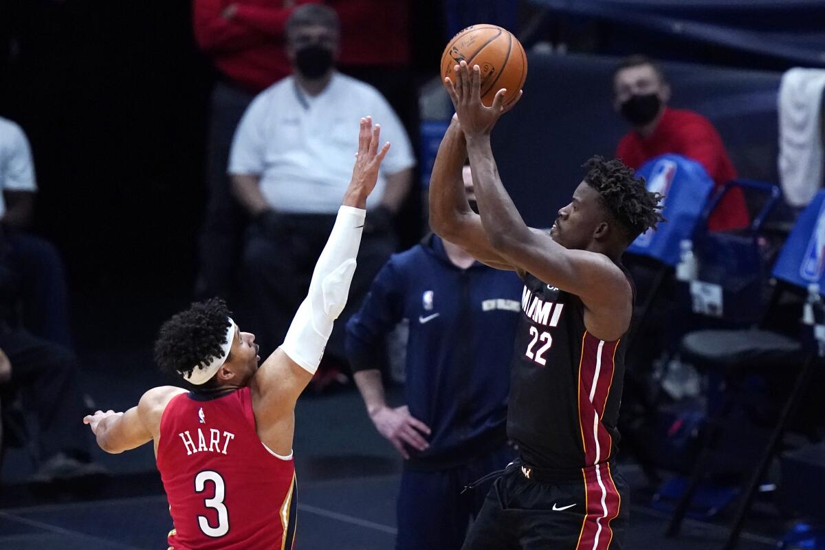 Miami Heat forward Jimmy Butler (22) shoots against New Orleans Pelicans guard Josh Hart (3) during the second half of an NBA basketball game in New Orleans, Thursday, March 4, 2021. (AP Photo/Gerald Herbert)
