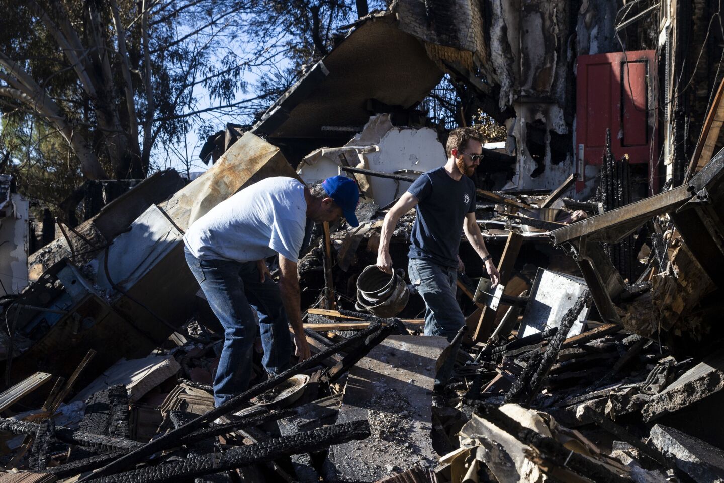 Keith Clark, left, and Shane Clark sift through the rubble of Shane Clark's Bell Canyon home, which was consumed by the Woolsey fire.