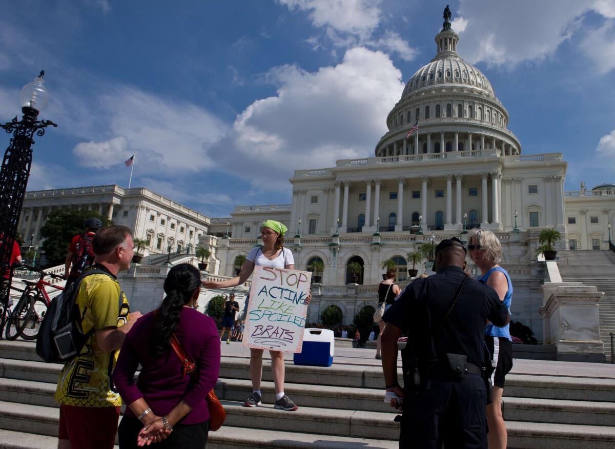 A protester speaks to tourists in front of the Capitol on the fifth day of the government shutdown.