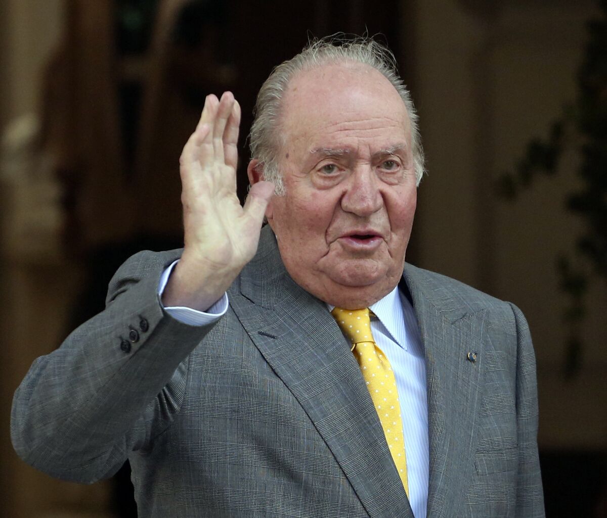 FILE - Spain's former King Juan Carlos waves upon his arrival to the Academia Diplomatica de Chile, in Santiago. Spain's Royal House said on Monday March 7, 2022 that King Felipe VI is accepting his father's desire to return to Spain for periodical visits, although former king Juan Carlos I will remain based in the United Arab Emirates where he moved in 2020 following probes into his financial dealings. The prosecutors didn't find evidence to take the former monarch to court because much of the financial misbehavior, involving millions of euros (dollars) in undeclared accounts, happened when Juan Carlos was protected by immunity as king of Spain and other possible fraud fell out of the statute of limitations. (AP Photo/Esteban Felix, File)