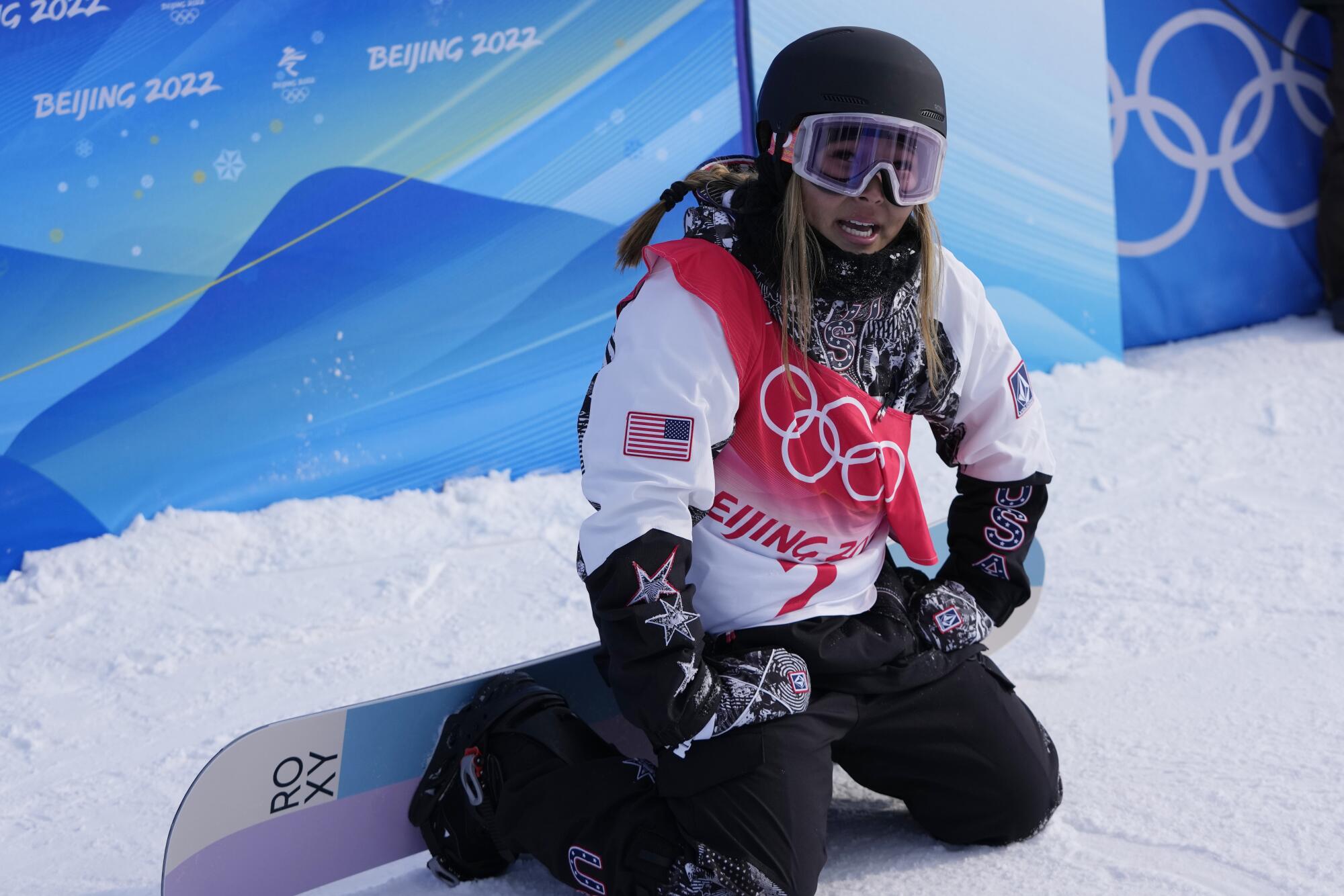 Chloe Kim sits on her knees following a run in the women's halfpipe finals at the 2022 Olympics