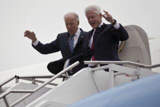Vice President Joe Biden, left, accompanied by former President Bill Clinton walk carefully off Air Force Two during a rainstorm,, upon their arrival in Youngstown, Ohio, for a campaign stop, Monday, Oct. 29, 2012. (AP Photo/Matt Rourke)