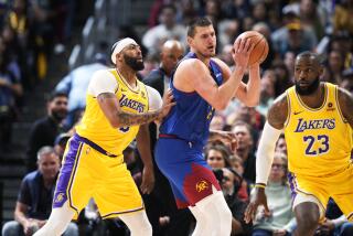 Denver Nuggets center Nikola Jokic, center, looks to pass the ball as Los Angeles Lakers.