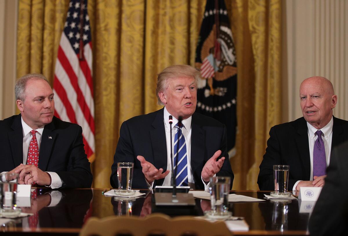 President Trump speaks as House Majority Whip Steve Scalise (R-La.), left, and Rep. Kevin Brady (R-Texas) listen in the East Room of the White House on Tuesday.
