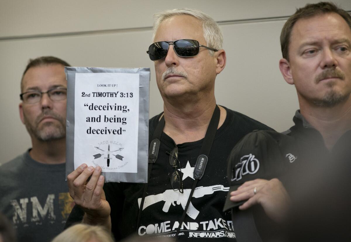 Bob Welch holds a sign at a public hearing about the Jade Helm 15 military training exercise in Bastrop, Texas.