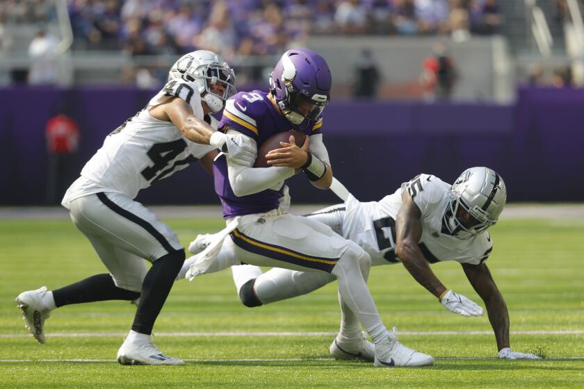 El mariscal de campo de los Vikings de Minnesota, J.J. McCarthy (9), es golpeado por el safety de los Raiders de Las Vegas, Jaydon Grant (40), mientras luchaba por yardas durante la primera mitad de un partido de fútbol americano de la NFL, el sábado 10 de agosto de 2024, en Minneapolis. (AP Foto/Bruce Kluckhohn)