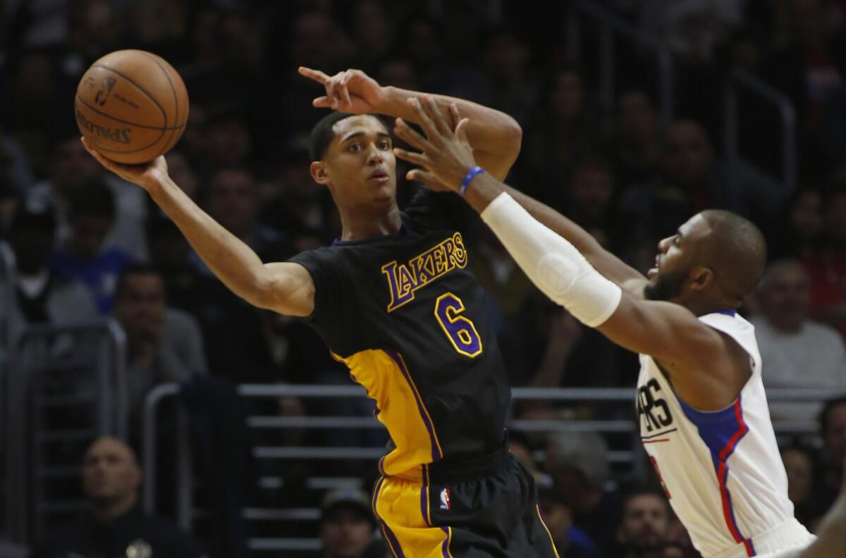 Lakers' Jordan Clarkson, left, passes as Clippers' Chris Paul, right, reaches in during the second quarter on Friday.