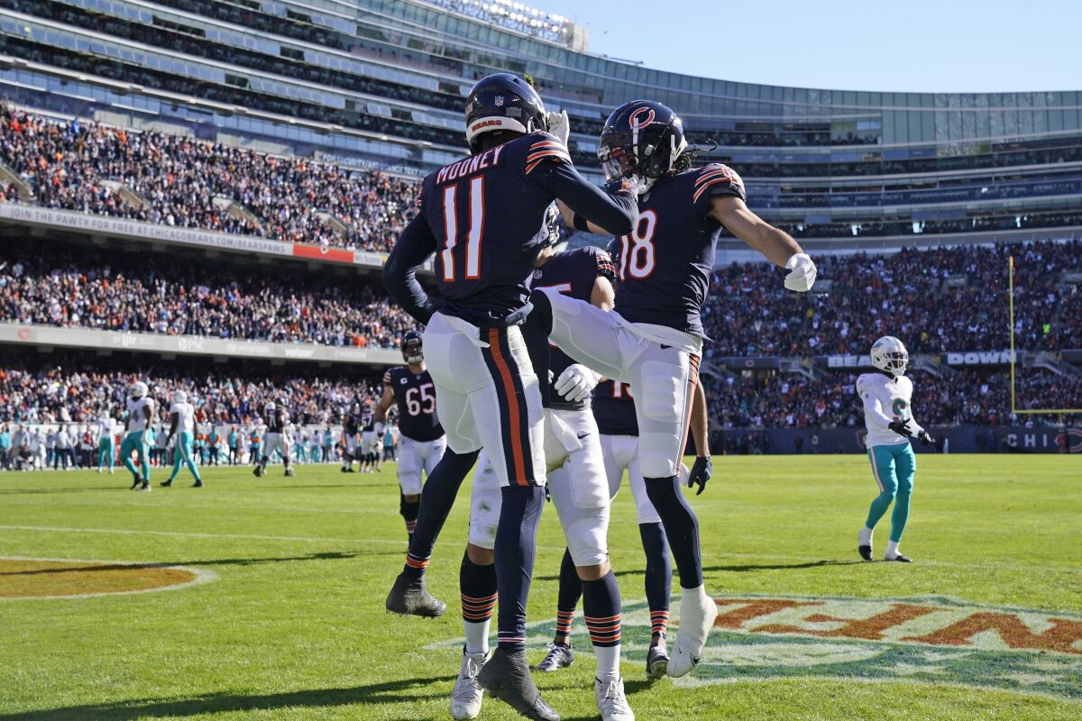 Chicago Bears wide receiver Darnell Mooney (11) celebrates his touch down with wide receiver Dante Pettis (18) during the first half of an NFL football game, Sunday, Nov. 6, 2022 in Chicago. (AP Photo/Nam Y. Huh)