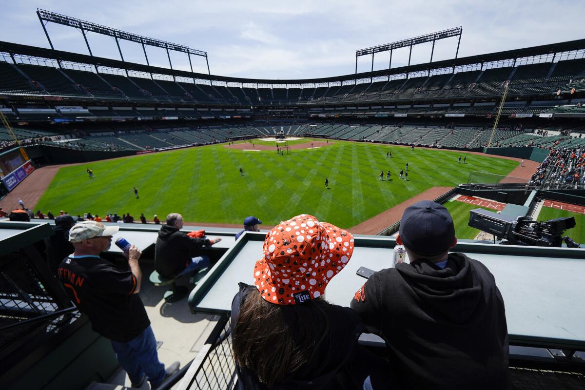 Fans watch batting practice before a game between the Baltimore Orioles and the Milwaukee Brewers.