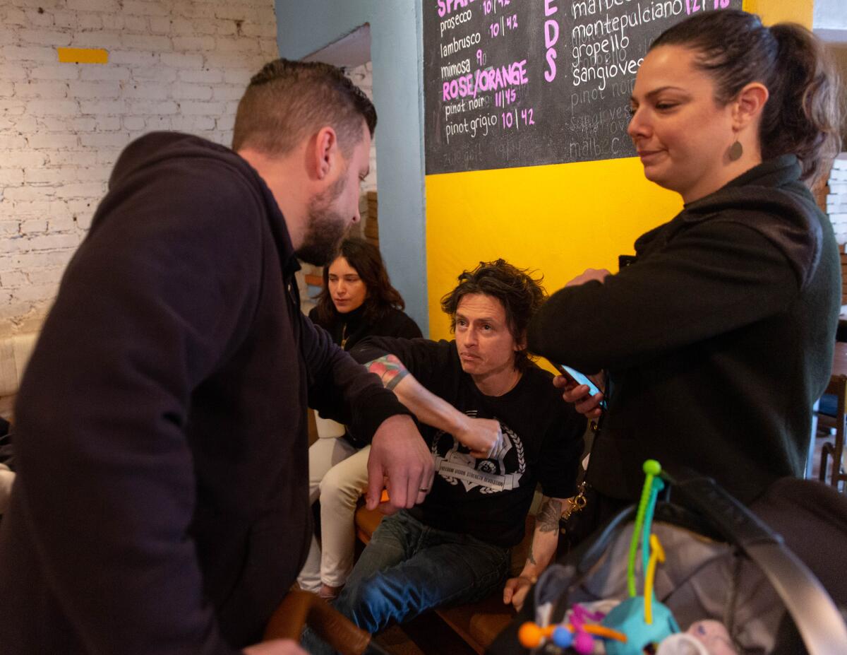 Daniel Cutler, left, pumps elbows with Hail Mary owner David Wilcox and restaurant recruiter Kristel Arabian.