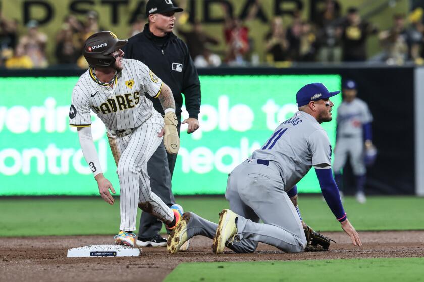 San Diego, CA, Tuesday, October 8, 2024 - Los Angeles Dodgers shortstop Miguel Rojas (11) picks himself up after flipping over San Diego Padres outfielder Jackson Merrill (3) on a botched double play attempt in game three of the National League Diviisional Series at Petco Park. (Robert Gauthier/Los Angeles Times)